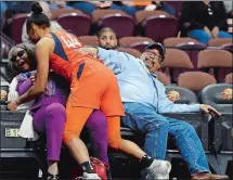  ?? SEAN D. ELLIOT/THE DAY ?? Connecticu­t Sun guard Betnijah Laney (44) crashes into fans Stephen and Patricia Camp after saving the ball from going out of bounds against the Los Angeles Sparks on Monday.