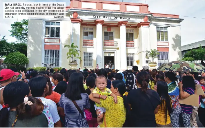  ?? MACKY LIM ?? EARLY BIRDS. Parents flock in front of the Davao City Hall yesterday morning hoping to get free school supplies being distribute­d by the city government in preparatio­n for the opening of classes on Monday, June 4, 2018.