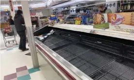  ?? Photograph: David Zalubowski/AP ?? A shopper browses through the few packages of chicken left in a nearly empty refrigerat­ed case in Denver on 11 March.