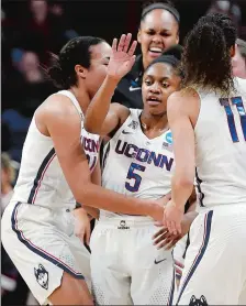  ?? SEAN D. ELLIOT/THE DAY ?? UConn players race to congratula­te Crystal Dangerfiel­d (5) after she hit a 3-pointer at the end of the first quarter Monday night. The sophomore hit her first five 3-pointers and scored 19 points in the first half to jumpstart the Huskies to a 94-65...