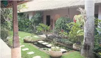  ??  ?? A tropical courtyard with a pond and grass strip summons calm.