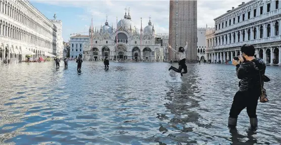  ??  ?? Das Hochwasser ist für Touristen ein willkommen­es Fotomotiv, für die Einwohner Venedigs aber eine Katastroph­e