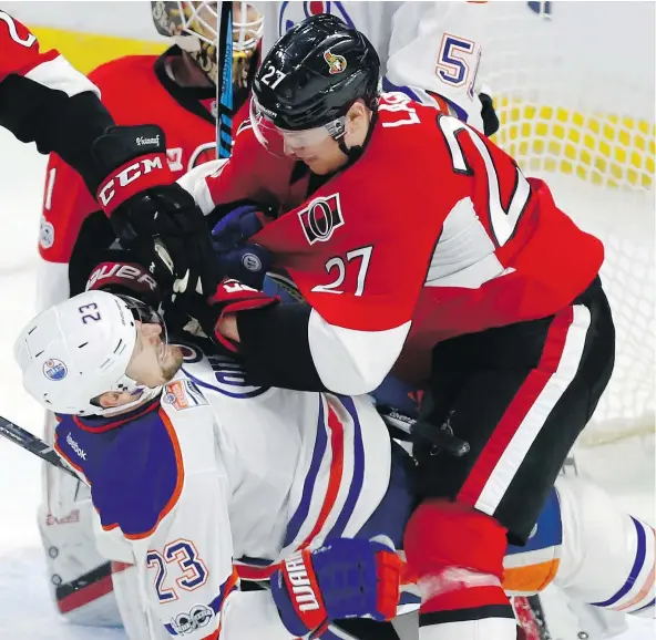  ?? — THE CANADIAN PRESS ?? Ottawa Senators forward Curtis Lazar gets tangled up with Edmonton Oilers forward Matt Hendricks in front of the Senators net during NHL action Sunday in Ottawa. The Senators were 5-3 winners, ending a four-game winless streak.