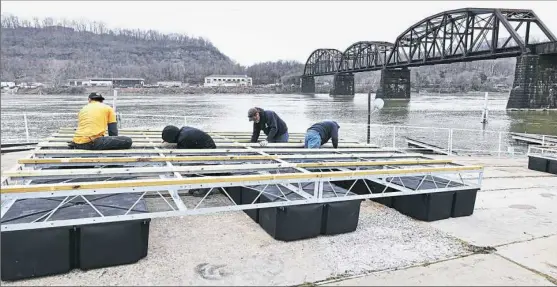  ?? Nate Guidry photos/Post-Gazette ?? Employees of Marion Hill Associates of New Brighton, Beaver County, assemble the docking system at the Aspinwall Marina.