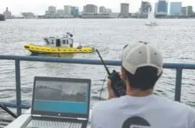  ?? Steven Senne, The Associated Press ?? Computer scientist Mohamed Saad Ibn Seddik, of Sea Machines Robotics, uses a laptop last month to guide a boat outfitted with sensors and self-navigating software and capable of autonomous navigation in Boston Harbor.