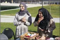  ?? ?? Nadir (left) and Shier talk May 7 with students attending the University of St. Thomas’ Ramadan celebratio­n.