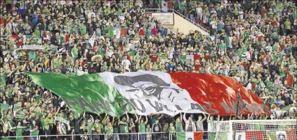  ?? ERIK VERDUZCO/LAS VEGAS REVIEW-JOURNAL ?? The Pancho Villa Army — the fervent U.S.-based fan club of the Mexican national soccer team — unfurls its banner at one end of Sam Boyd Stadium during Mexico’s friendly against Iceland on Wednesday night.