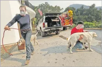  ?? Mel Melcon Los Angeles Times ?? MONTECITO residents Mary McEwen, left, and her husband, Dan Bellaart, prepare in case of having to evacuate last December during the Thomas fire. Bring what you need to control pets.