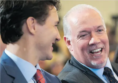  ?? DARRYL DYCK / THE CANADIAN PRESS ?? B.C. Premier John Horgan, right, speaks to Prime Minister Justin Trudeau during an LNG Canada news conference.