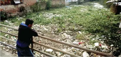  ?? BOY SLAMET/JAWA POS ?? TIDAK BERTANGGUN­G JAWAB: Sampah-sampah yang dibuang sembaranga­n ke sungai menutup permukaan Kali Buntung di kawasan Waru kemarin.