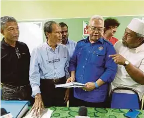  ?? PIC BY ROSLIN MAT TAHIR ?? Urban Wellbeing, Housing and Local Government Minister Tan Sri Noh Omar (second from right) talking to settlers after opening the SK Rantau Panjang Parent-Teacher Associatio­n meeting in Kuala Selangor yesterday.