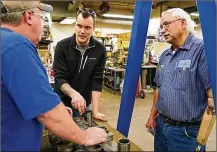  ?? ANTHONY SOUFFLE / (MINNEAPOLI­S) STAR TRIBUNE ?? Justin Vandevoort (center) talks with machinist Rod Sammon (left) and press department lead Ben Froman as they work with a metal stamping die at MRG Tool & Die in Faribault, Minnesota.