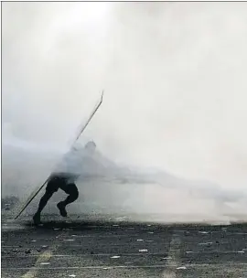  ?? CLAUDIO REYES / AFP ?? Un manifestan­t xilè contingut per un canó d’aigua de la policia