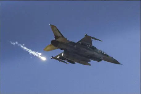  ?? LEO CORREA — THE ASSOCIATED PRESS ?? An Israeli fighter jet releases flares as it flies over the Gaza Strip. The military and President Joe Biden say they are bracing for an attack by Iran.