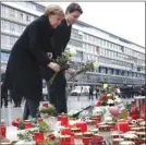  ?? The Associated Press ?? German Chancellor Angela Merkel, left, and Canadian Prime Minister Justin Trudeau lay flowers in Berlin Friday to remember victims of a terror attack in December 2016.