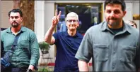  ?? PHOTO: AFP ?? Apple Inc CEO Tim Cook, center, gestures while crossing a street in downtown Hanoi yesterday.