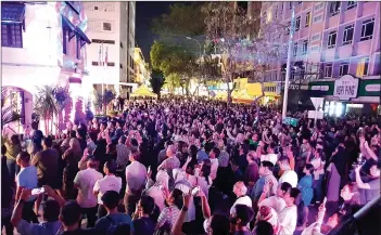  ?? ?? The crowd watching the laser light show projected on the STB building.