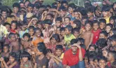  ??  ?? Rohingya children watching a Bangladesh­i theater group.