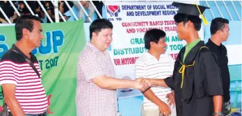  ?? Rochlem Concepcion/Samal Info ?? PASSED WITH FLYING COLORS. Samal City Mayor Al David T. Uy congratula­tes one of the graduates of the Motorcycle and Small Engine Servicing NCII together with Vice Mayor Orly Amit (third to left) and members of 7th City Council, Richard Guindolman (4th...