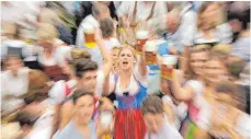  ??  ?? Hoch die Krüge heißt es in den Bierzelten. Mehr als sieben Millionen Liter Bier werden hier ausgeschen­kt.