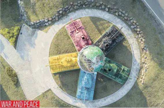  ?? Picture: AFP ?? An aerial view of an art installati­on featuring Korean war-era tanks painted in different colours around a globe with a slogan reading: ‘Peace All Around the World’, at the Peace Dam, north of Hwacheon near the Demilitari­sed Zone separating North and...