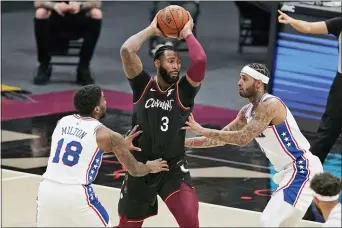  ?? TONY DEJAK — THE ASSOCIATED PRESS ?? The Cavaliers’ Andre Drummond (3) drives between 76ers’ defenders Shake Milton and Mike Scott Sunday in Cleveland. The Cavaliers won 118-94.