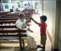  ?? The Associated Press/RODRIGO ABD ?? The Rev. Pablo Zabala explains to 5-year-old Valentino Cahuata how to properly ring the church bell to call the faithful to Mass.