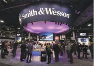 ?? Ethan Miller / Getty Images ?? People visit Smith & Wesson’s booth at a Shooting, Hunting, Outdoor Trade Show in Las Vegas.