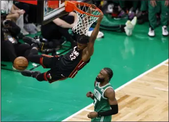  ?? PHOTOS BY MICHAEL DWYER — THE ASSOCIATED PRESS ?? Miami Heat forward Jimmy Butler, left, dunks as Boston Celtics guard Jaylen Brown defends during the second half in Game 7 of the Eastern Conference Finals on Monday in Boston.