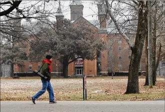  ?? TY GREENLEES / STAFF ?? A bundled up visitor to the Wellness Center at Antioch College passes Antioch Hall on a frosty morning in Yellow Springs. The Wellness Center opened in 2014 with 44,000-square-feet of space for physical fitness and programs for members.