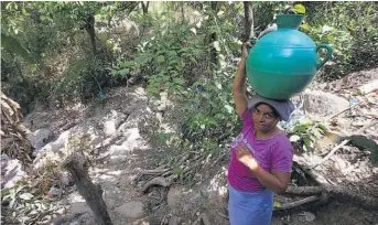  ??  ?? Mujeres y niñas suelen ser las encargadas de acarrear agua.