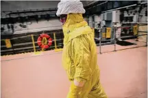  ?? Staff file photo ?? A worker in protective gear walks past the spent fuel pool at the South Texas Nuclear Project Electric Generating Station.