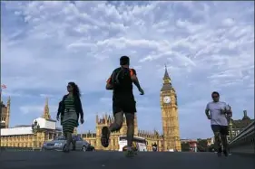  ??  ?? Joggers cross Westminste­r Bridge beside the Houses of Parliament and the Big Ben clock tower in London in 2016. One way to maintain an exercise regime on vacation is to seek out local running clubs or ask a concierge to help you map a safe running route.