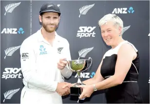  ?? — AFP photo ?? New Zealand’s captain Kane Williamson (L) receives the ANZ test series cup from NZ Cricket President Debbie Hockley after their series win during day five of the second cricket Test match between New Zealand and Sri Lanka at Hagley Park Oval in Christchur­ch, New Zealand on December 30, 2018.