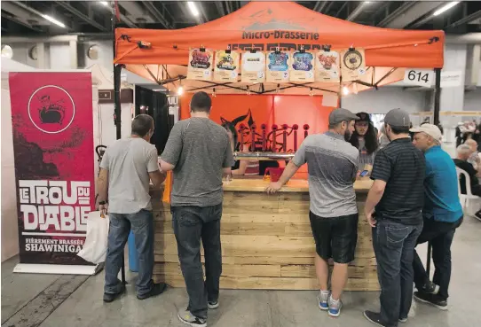  ?? PHOTOS: PIERRE OBENDRAUF ?? People gather around the kiosk of Trou du Diable microbrewe­ry at the Mondial de la bière at the Palais des congrès on June 16.