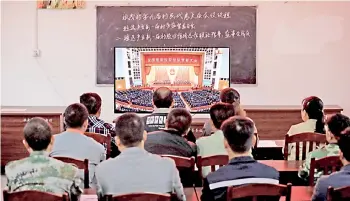  ?? — AFP photo ?? People watch a livestream of the ceremony to mark the country’s accomplish­ments in poverty eradicatio­n after Xi declared his country had achieved the “human miracle” of eliminatin­g extreme poverty, at a village in Liuzhou, in southern China’s Guangxi province.