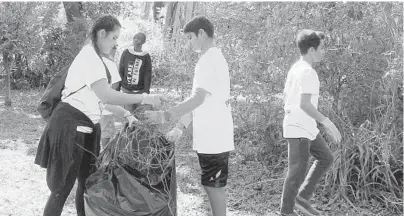  ??  ?? Students from Pompano Beach Middle School rip out air potato weeds at Snyder Park on Saturday.