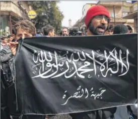  ?? AP ?? Anti-Syrian President Bashar Assad protesters hold the Nusra Front flag as they shout slogans during a demonstrat­ion in Idlib province, northern Syria. The Nusra Front, Syria’s al-Qaida affiliate, is consolidat­ing power from the Turkish border to...