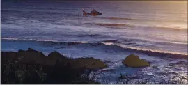  ?? CALFIRE ?? A U.S. Coast Guard helicopter searches for a 12-year-old boy who was swept into the ocean at Cowell Ranch State Beach in San Mateo County on Monday.