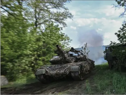  ?? ARIS MESSINIS — AFP VIA GETTY IMAGES ?? Ukrainian servicemen man a tank at a frontline position near the city of Lysychansk in eastern Ukraine on Friday.