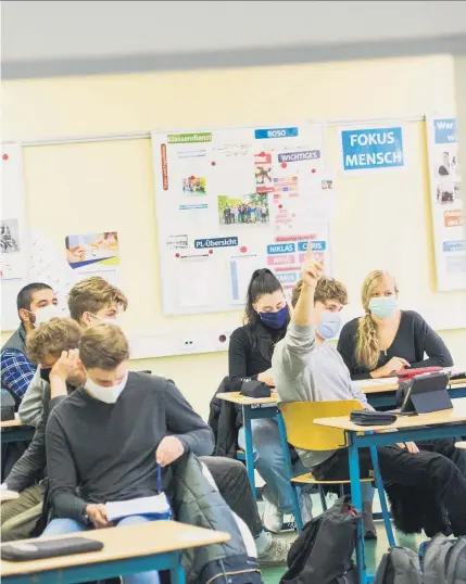  ??  ?? Geteilte Klassen sollen in Berlin vermieden werden. So bleibt es kuschlig beengt im Unterricht, jetzt neu mit Maske.