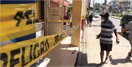  ??  ?? CAMBIOS. En la zona comercial de Esmeraldas se ha vuelto más frecuente el uso de cintas de seguridad para evitar aglomeraci­ones.