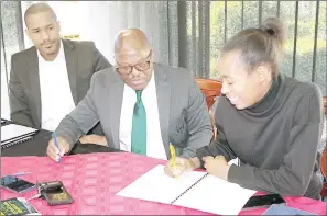  ?? (Pics: Pholsile Hlophe) ?? Sprinter Bongiwe Mahlalela signs her scholarshi­p form while EOCGA President Adam ‘Bomber’ Mthethwa (C) and CEO Maxwell Jele pay close attention during the handover of the athlete scholarshi­p.