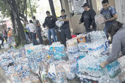  ?? PHOTO: GETTY IMAGES , ?? Helping hands . . . Volunteers collect aid to assist people at the collapsed Enrique Rebsamen School in Mexico City yesterday.