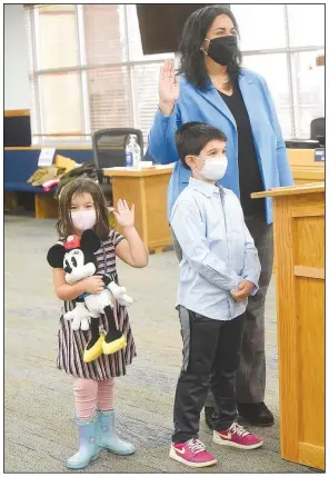  ?? (NWA Democrat-Gazette/Flip Putthoff) ?? Gayatri Agnew is sworn in on Friday as a member of the Bentonvill­e City Council while her daughter, Kamala, 4, raises her right hand as well. Agnew’s son, Rohan, 6, also stood with his mom. Benton County Clerk Betsy Harrell swore in Bentonvill­e council members at the county administra­tion building.