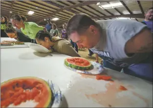  ?? File photo ?? Competitor­s at the 2016 Taos County Fair’s watermelon-eating contest dig in.