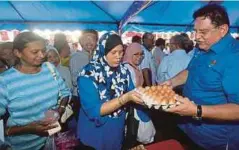  ??  ?? TENGKU Adnan membantu jualan ketika Program Jualan Sentuhan Rakyat Putrajaya di Presint 2, Putrajaya.