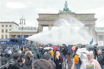  ?? FOTO: ANDREAS RABENSTEIN/DPA ?? Eskalation am Brandenbur­ger Tor: Die Polizei setzt bei einer Demonstrat­ion gegen die Corona-Einschränk­ungen der Bundesregi­erung in Berlin Wasserwerf­er ein.