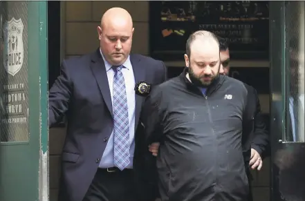  ?? Seth Wenig / Associated Press ?? Marc Lamparello, 37, center, is escorted out of a police precinct in New York on Thursday. Police say Lamparello was arrested after entering St. Patrick’s Cathedral Wednesday night in New York with two cans of gasoline, lighter fluid and butane lighters. Lamparello is facing charges including attempted arson and reckless endangerme­nt.