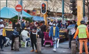  ?? (Bloomberg (WPNS)/Waldo Swiegers) ?? Shoppers walk through a market last month in the central business district of Pretoria, South Africa.